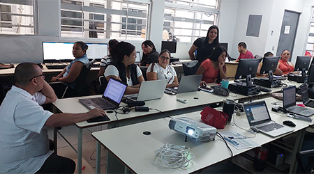 Se muestra un laboratorio computadoras y personas recibiendo clases